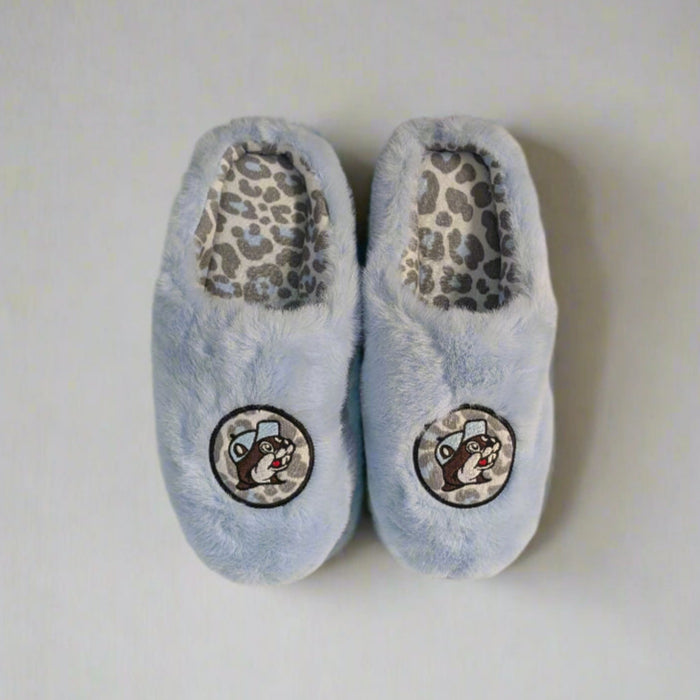Top-down view of Buc-ee’s light blue fuzzy slippers with leopard print lining and embroidered beaver logo on top.