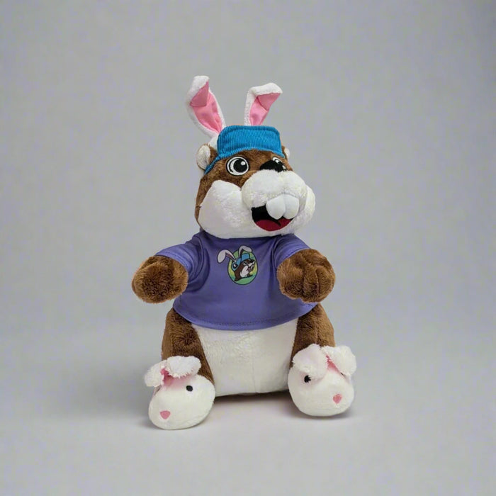 Buc-ee's Easter Plushie with bunny ears and a blue hat. Bunny slippers on with the purple pastel theme Easter shirt.