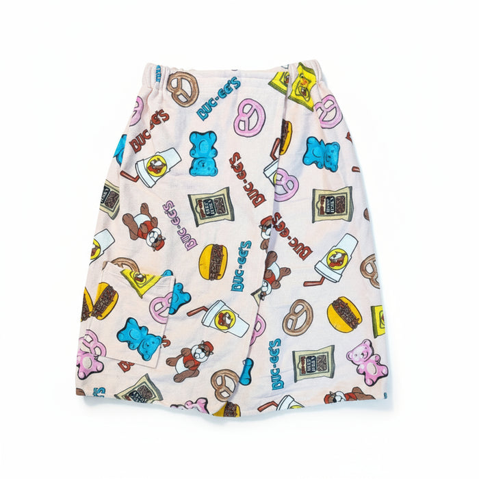 Buc-ee's Snack Towel Wrap has a velcrow stretchy top to hold around you and a front pocket in the front along with the design has blue gummy bears, brisket sandwiches, beaver nuggers, drinks all over it.