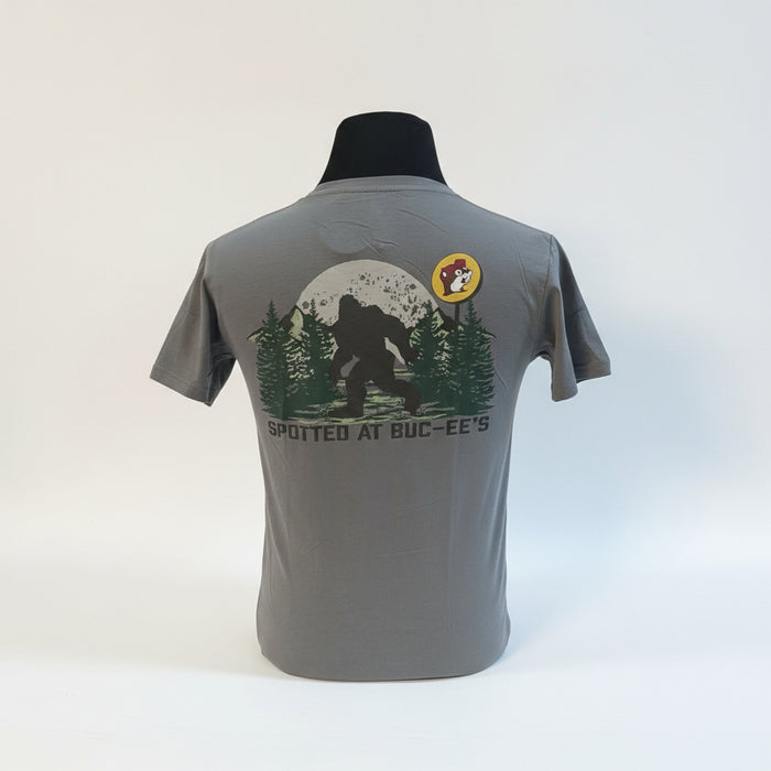 The Buc-ee’s “Spotted at Buc-ee’s” Shirt captures the legendary moment Bigfoot was seen grabbing snacks under the Texas stars. Featuring a classic gray tee with a bold Buc-ee’s logo on the front and a mysterious Bigfoot silhouette against a moonlit forest on the back, this shirt is perfect for fans of roadside adventures and tall tales alike.