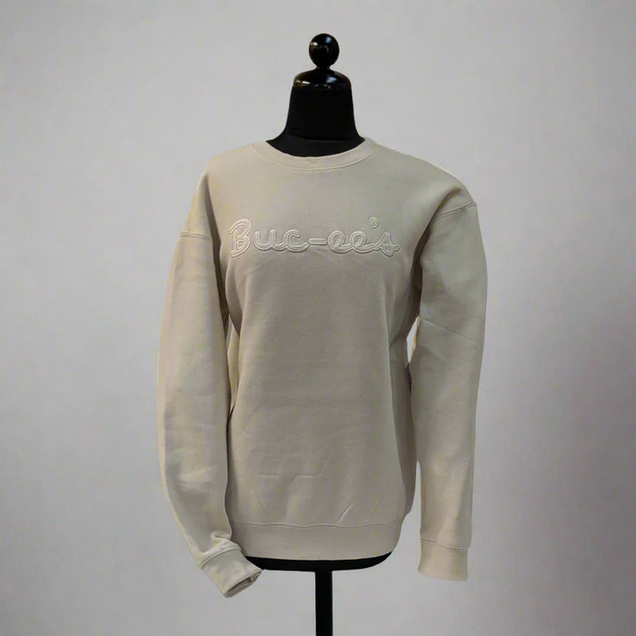Front view of a cream-colored Buc-ee’s sweater with embroidered Buc-ee’s script across the chest, displayed on a mannequin.