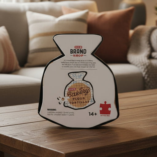 Back view of the H-E-B Bakery Flour Tortilla Puzzle box, showing a small image of the completed puzzle, product details, and branding information printed on a white background.