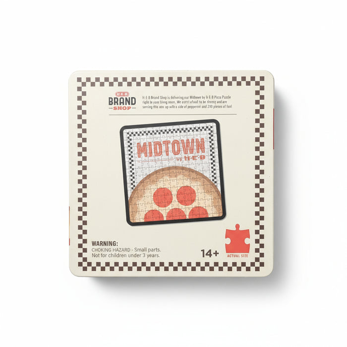 Back view of the H-E-B Midtown by H-E-B Puzzle box showing an image of the completed pizza-themed puzzle, product details, and H-E-B Brand Shop branding printed on a beige background with a checkered border.