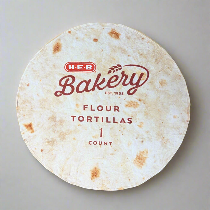 HEB Tortilla Blanket. Blanket in the shape of a tortilla and has Bakery and HEB on it.