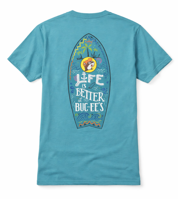 Back of the 'Life is Better at Buc-ee's' Turquoise Shirt showing a large surfboard graphic with palm trees, waves, and the text 'Life is Better at Buc-ee's'." Displayed on a clean white background.