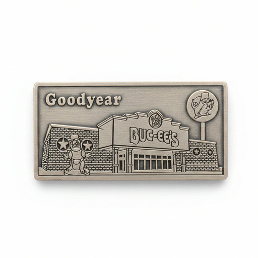 Metallic embossed design of a building with 'Goodyear' branding on a wooden surface