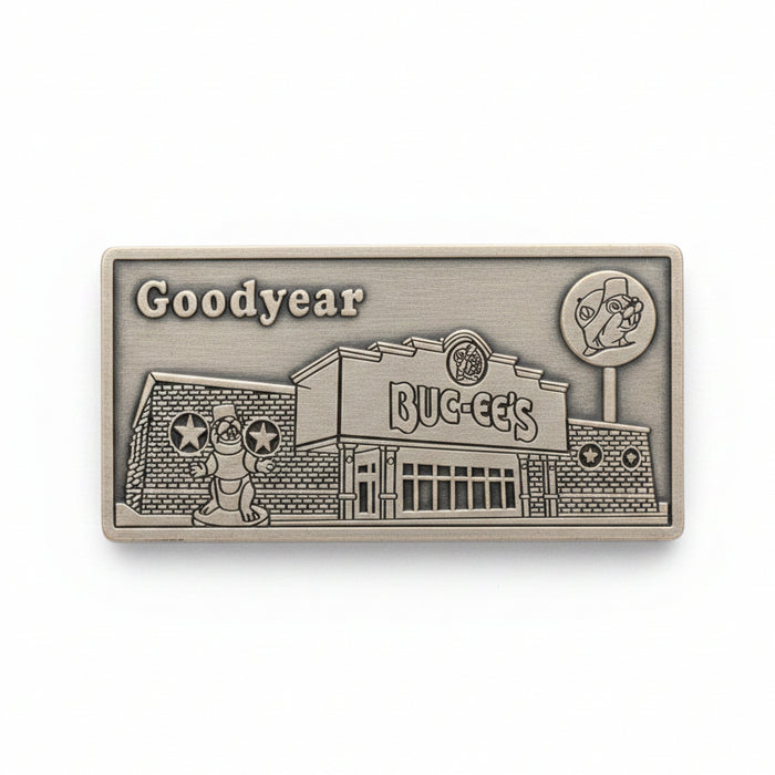 Metallic embossed design of a building with 'Goodyear' branding on a wooden surface