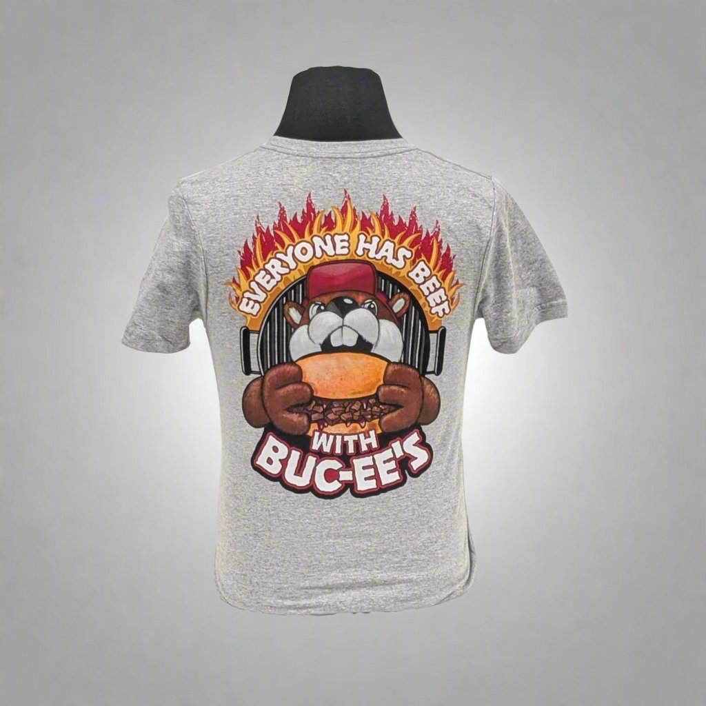 The back of a gray t-shirt featuring a bold design of the Buc-ee's mascot holding a burger with the slogan "Everyone Has Beef With Buc-ee's" surrounded by flames.