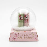 Buc-ee's Lip Balm Collection packaging styled like a clear snow globe on a pink floral base displaying "LIP BALM COLLECTION" with Sugar Cookie and Candy Cane lip balms inside.