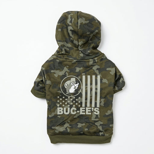 Back view of a green camo pet hoodie laid flat, showing a white US flag-inspired print featuring Buc-ee the Beaver and "BUC-EE'S" text across the back.