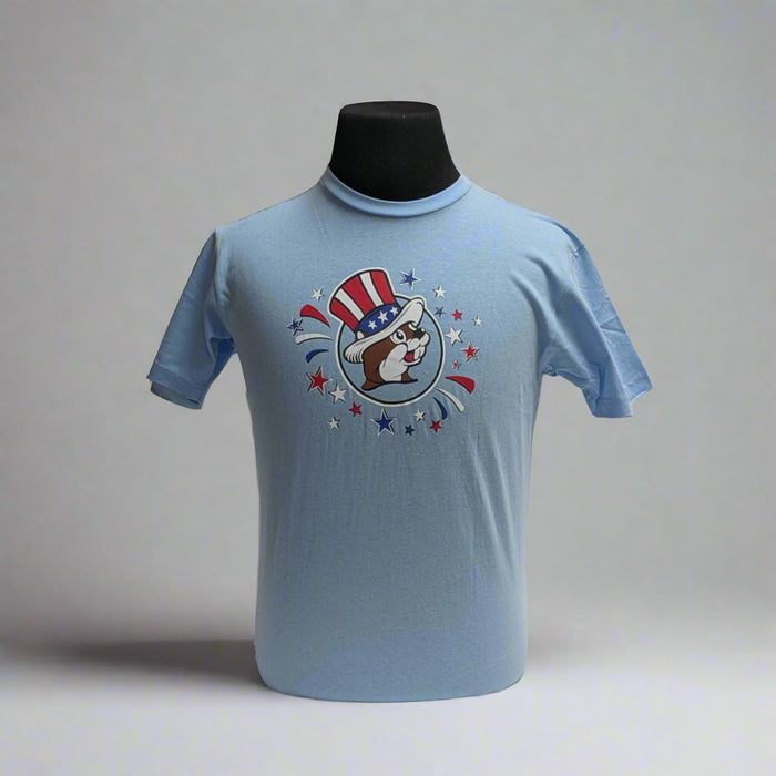 Buc-ee's 4th of July Shirt "Sweet Land of Liberty". Baby blue with logo on the front with the "Sweet land of Liberty" on the back with Buc-ee on a tube in the summer time.