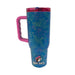 Back view of the blue Buc-ee's Alabama tumbler showing the continuous rose and leaf pattern. The pink handle is positioned on the left side, and a small circular Buc-ee's logo with the mascot wearing a pink hat is printed near the bottom base.