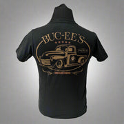 Back of a black Buc-ee’s t-shirt with a large vintage-style truck graphic in bronze and “BUC-EE’S – American Original” text.