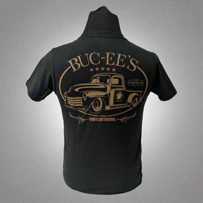 Back of a black Buc-ee’s t-shirt with a large vintage-style truck graphic in bronze and “BUC-EE’S – American Original” text.