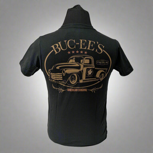 Back of a black Buc-ee’s t-shirt with a large vintage-style truck graphic in bronze and “BUC-EE’S – American Original” text.