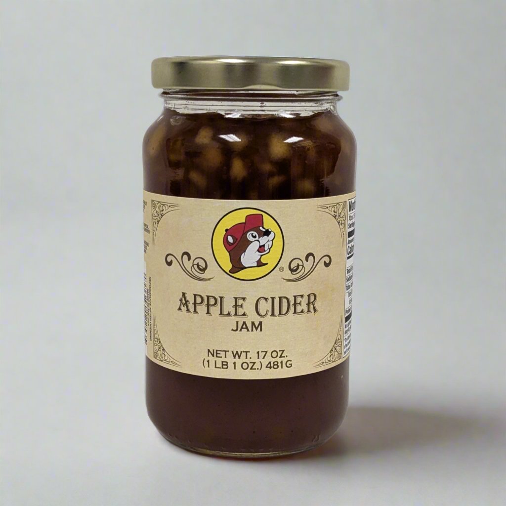 A 17 oz. jar of Apple Cider Jam with a golden lid, featuring a label adorned with a playful mascot and "Apple Cider Jam" text, showcasing its rich, spiced apple filling.