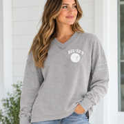 Woman wearing a washed gray Buc-ee’s long-sleeve tunic with bold white “BUC-EE’S” lettering across the chest and stitched stripe details on the sleeves.