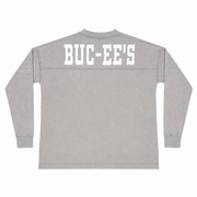 Back view of a mineral-washed ash grey long-sleeve tunic shirt featuring large white "BUC-EE'S" block letters across the back shoulders.