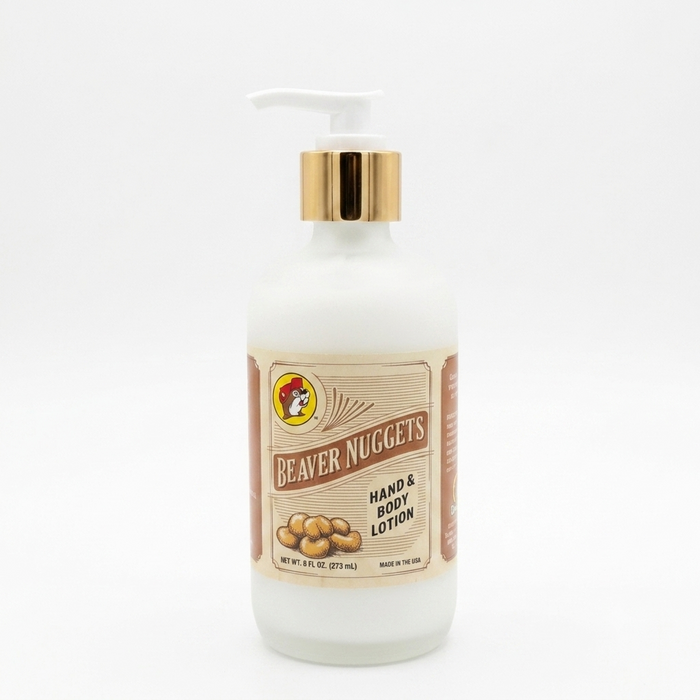 A square product shot of an 8 oz frosted glass pump bottle of Buc-ee's Beaver Nuggets Hand & Body Lotion, featuring a gold neck collar and a white pump nozzle pointing to the left, isolated against a seamless, solid white background.