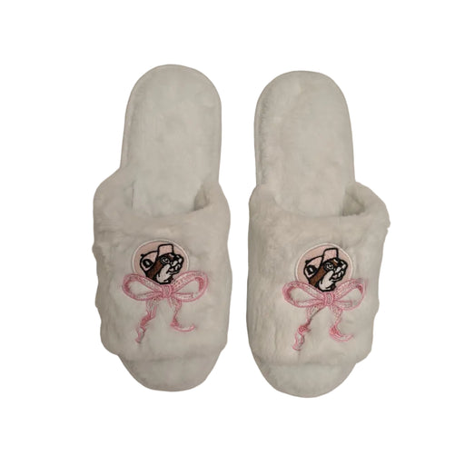 A pair of plush, open-toe faux fur slippers in a very light teal color. Each slipper features a circular patch of the Buc-ee's beaver mascot wearing a pink hat, positioned directly above an embroidered decorative pink ribbon bow with trailing ends. Displayed on a clean white background.