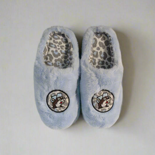 Top-down view of Buc-ee’s light blue fuzzy slippers with leopard print lining and embroidered beaver logo on top.