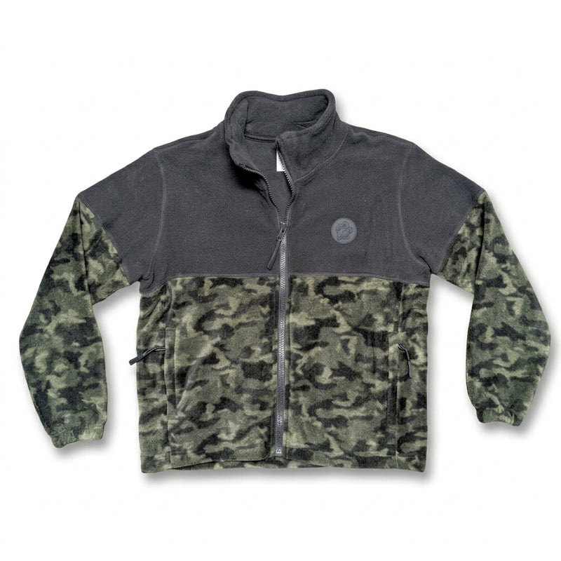 A front photo of a Buc-ee's Youth Camo Colorblock Fleece Jacket. The jacket features a solid charcoal grey upper yoke, a dark woodland camouflage lower body and sleeves, side zip pockets, and a round grey Buc-ee's beaver logo patch on the left chest.