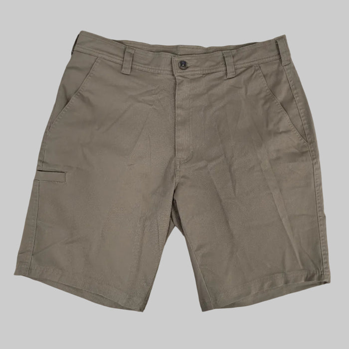A front view of the Buc-ee's Caribou Fishing Twill Shorts in deep earth-brown taupe, shown laid flat against a neutral grey background. The image features a classic button-waist closure with a zipper fly, deep front slash pockets, and reinforced belt loops. On the right leg (viewer's left), a low-profile, horizontal-entry utility tool slot is visible, designed for quick access to gear. The heavy-duty cotton-twill fabric displays a rugged, matte texture suitable for outdoor use.