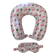An overhead view of a Buc-ee's Cherry matching travel set featuring a U-shaped neck pillow with a front snap closure and a matching elastic-band eye mask. Both items feature a pink and white vertical stripe design printed with the Buc-ee's beaver mascot, bows, and cherries. Displayed on a clean white background.