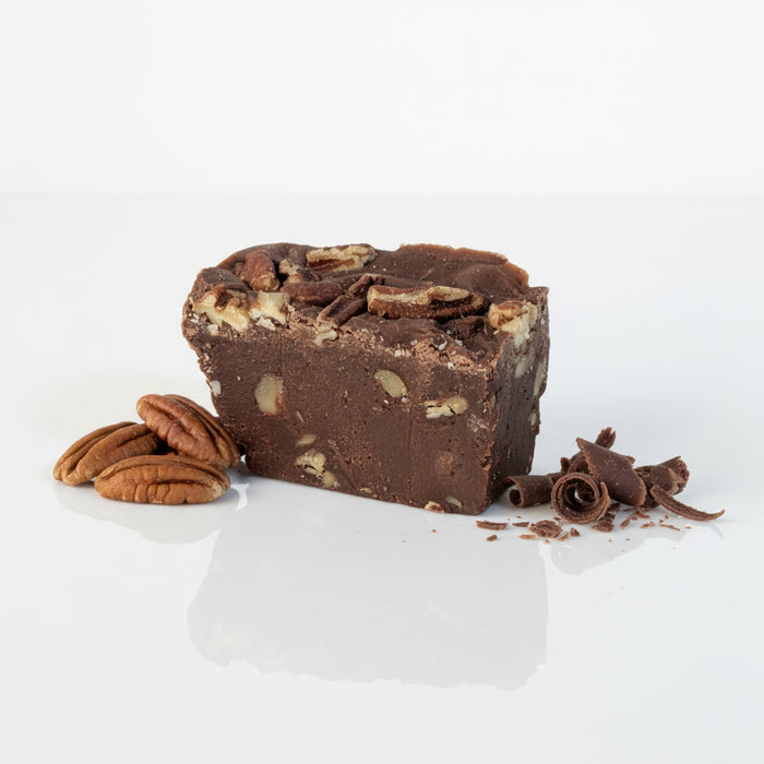 Block of chocolate fudge with white chips on a light gray background