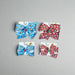Set of Buc-ee’s Holiday Hair Bows in Snowflake (blue) and Peppermint (red) designs, shown in large and small sizes.