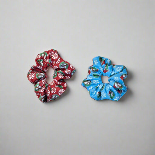 Set of Buc-ee’s Holiday Scrunchies in Snowflake (blue with snowflakes) and Peppermint (red with candy designs)