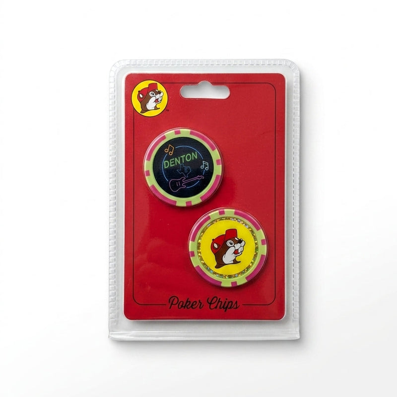 Packaged 2-piece collectible casino poker chip set on a red background. The top chip features a black center with neon graphics including an electric guitar, music notes, a Texas map outline, and the word "DENTON". The bottom chip displays the smiling Buc-ee's beaver mascot with a yellow center ringed in gold glitter, both featuring pink and lime green striped rims.