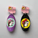 Buc-ee’s detangler brushes in two colors: one black with Buc-ee in a red cap, and one purple with Buc-ee surrounded by pink hearts, shown from front and back views.

