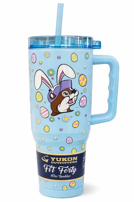 A light blue 40oz Yukon Outfitters "Fit Forty" tumbler with a large handle, blue lid, and straw. The design features the Buc-ee's beaver wearing bunny ears surrounded by colorful Easter eggs and daisies.