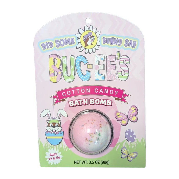 A Buc-ee's brand Cotton Candy bath bomb inside a clear plastic dome on a pink, spring-themed cardboard backing. The packaging features a cartoon Buc-ee beaver in an egg, butterflies, and the text 'DID SOME BUNNY SAY BUC-EE’S' and 'COTTON CANDY BATH BOMB'. Displayed on a clean white background.
