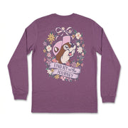 Back view of a heathered purple long-sleeve t-shirt featuring Buc-ee in a pink hat surrounded by a floral wreath, ribbon bow, and a banner reading "Find Joy in the Journey".