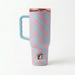 The back view of a 40-ounce Buc-ee's Fit Forty Pro travel tumbler showing the continuous pink palm leaf pattern over a light blue background. A large, light blue ergonomic handle with molded finger grooves is attached to the left side, and a small, circular Buc-ee's beaver logo is positioned near the tapered base. Displayed on a white background.