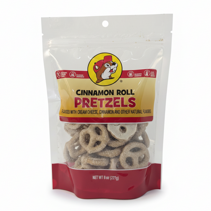 An 8 oz, stand-up resealable bag of Buc-ee's Cinnamon Roll Flavored Pretzels. The pretzels are coated in a textured, creamy white cinnamon roll icing. The packaging is clear, showing the product detail, and is placed on a smooth, clean white background.