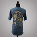 Back view of a blue Buc-ee’s t-shirt with a large floral Buc-ee’s graphic, Buc-ee’s script, and the phrase “Live Simple, Dream Big,” displayed on a mannequin.