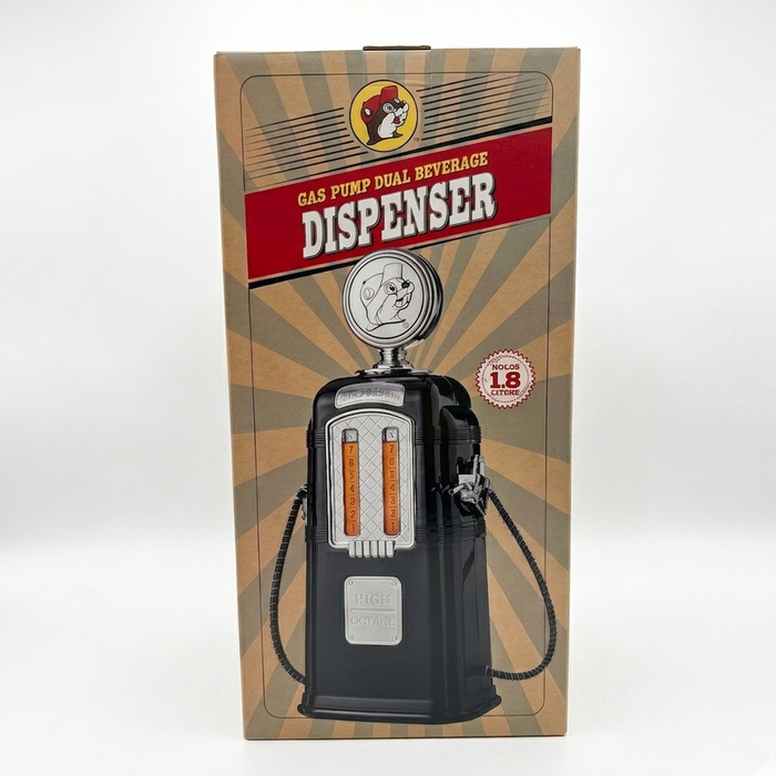A product photo of the Buc-ee's Gas Pump Dual Beverage Dispenser box. The image is a square composition on a clean, seamless white background. The box features a vintage-inspired design with a tan sunburst pattern, a red banner reading "GAS PUMP DUAL BEVERAGE DISPENSER," and the iconic Buc-ee’s beaver mascot logo at the top. The center of the box displays a high-quality illustration of the black, retro-style gas pump dispenser, including its chrome detailing, twin amber-filled reservoir marked 1 through 8.