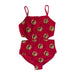 A flat lay product photograph of a Buc-ee's Red Logo one-piece girls' swimsuit featuring side cut-out details. The suit has thin camisole-style straps and a straight neckline. It is covered in an all-over repeating pattern of the yellow and red Buc-ee’s beaver logo. The garment is laid flat on a clean, white neutral surface.