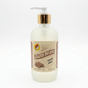 Front view of an 8 oz bottle of Buc-ee's Glazed Pecans Hand Soap. The liquid soap is contained in a frosted bottle with a vintage-style label, a white pump, and a metallic gold collar, set against a plain white background.