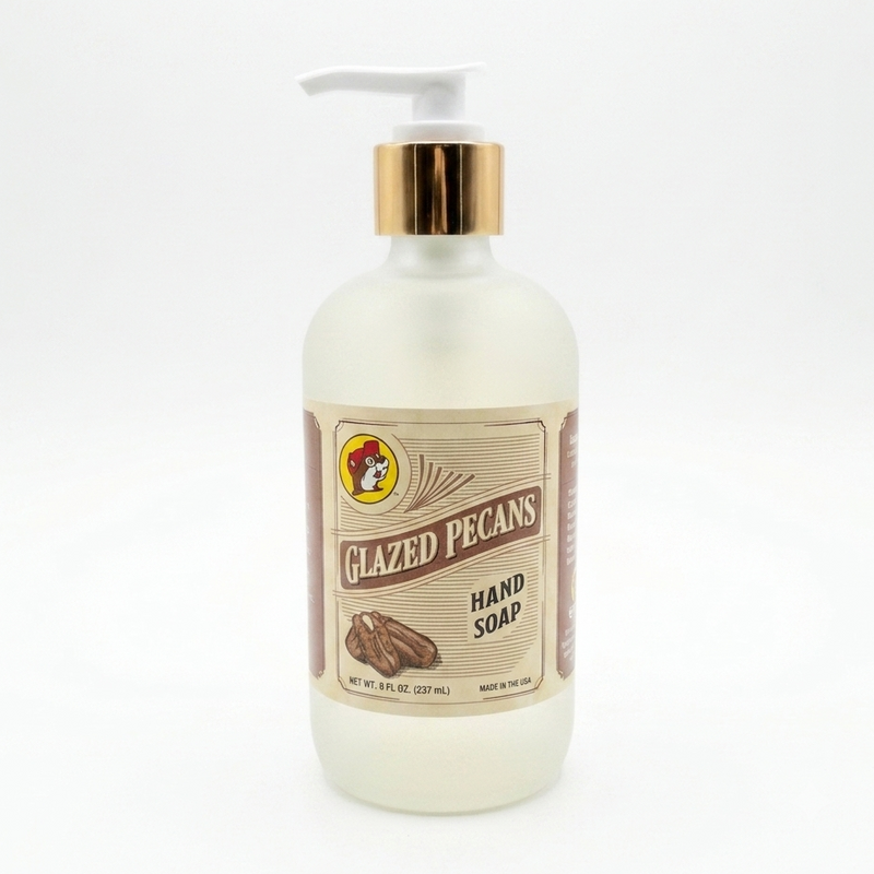 Front view of an 8 oz bottle of Buc-ee's Glazed Pecans Hand Soap. The liquid soap is contained in a frosted bottle with a vintage-style label, a white pump, and a metallic gold collar, set against a plain white background.
