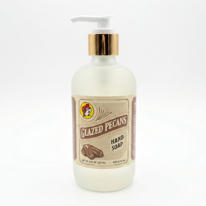 Front view of an 8 oz bottle of Buc-ee's Glazed Pecans Hand Soap. The liquid soap is contained in a frosted bottle with a vintage-style label, a white pump, and a metallic gold collar, set against a plain white background.