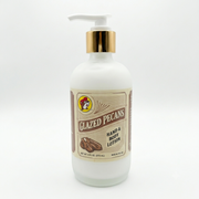 A square product shot of an 8 oz frosted glass pump bottle of Buc-ee's Glazed Pecans Hand & Body Lotion, featuring a gold neck collar and a white pump nozzle pointing to the left, isolated against a seamless, solid white background.