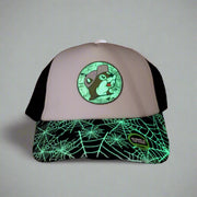 Buc-ee’s glow-in-the-dark trucker hat glowing in a dark room, highlighting the spiderweb brim and logo