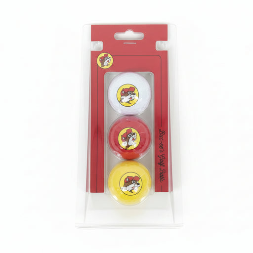 A photo of a Buc-ee’s 3-pack golf ball set in its original retail packaging. The set is displayed in a clear, transparent plastic blister pack with a red cardboard backing. Inside are three golf balls in vertical alignment: white on top, red in the middle, and yellow on the bottom, each featuring the full-color Buc-ee’s beaver logo. The red packaging includes the "Buc-ee’s Golf Balls" script on the side and a hanging slot at the top, shown against a clean, neutral white background.