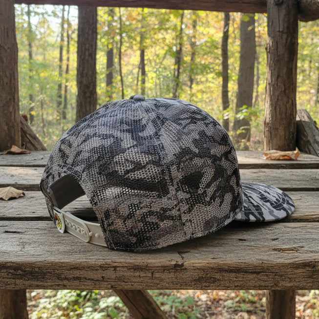 Rear angled view of a Buc-ee’s green camouflage trucker hat featuring a breathable mesh back and adjustable snap closure strap.