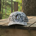 Front view of a Buc-ee’s green camouflage trucker hat featuring the embroidered Buc-ee’s beaver logo on the front panel.