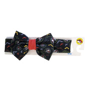 Buc-ee's Halloween soft fabric headband with an oversized bow featuring vampire Buc-ee and neon bats with a red-orange center knot on a packaging hanger.